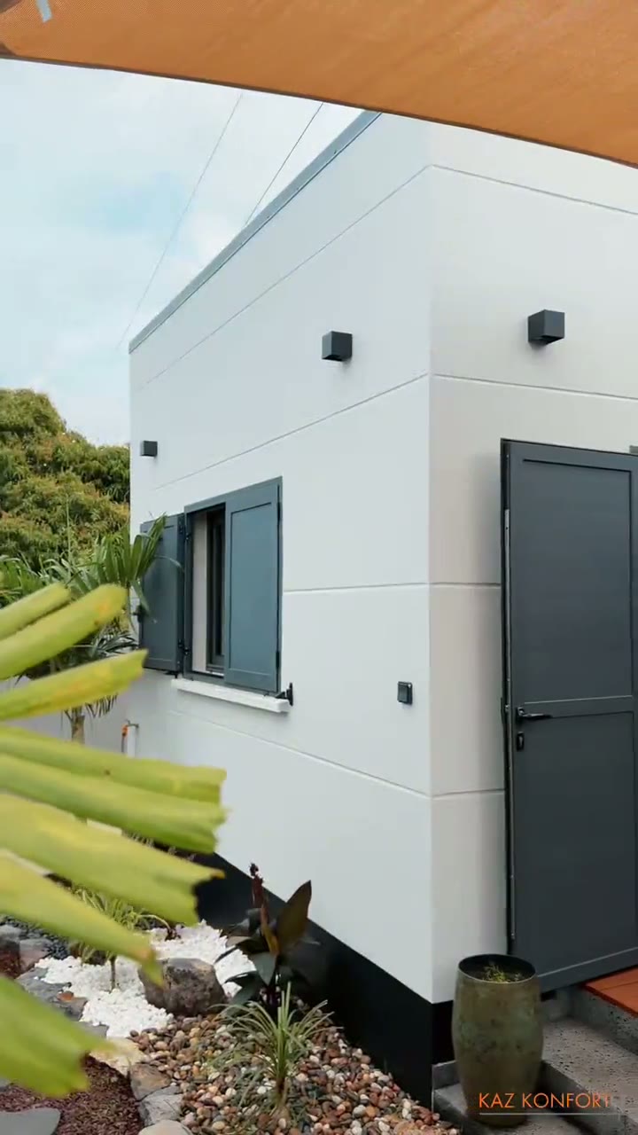 Villa contemporaine blanche avec volets anthracite et jardin tropical, réalisée par KAZ KONFORT PLUS