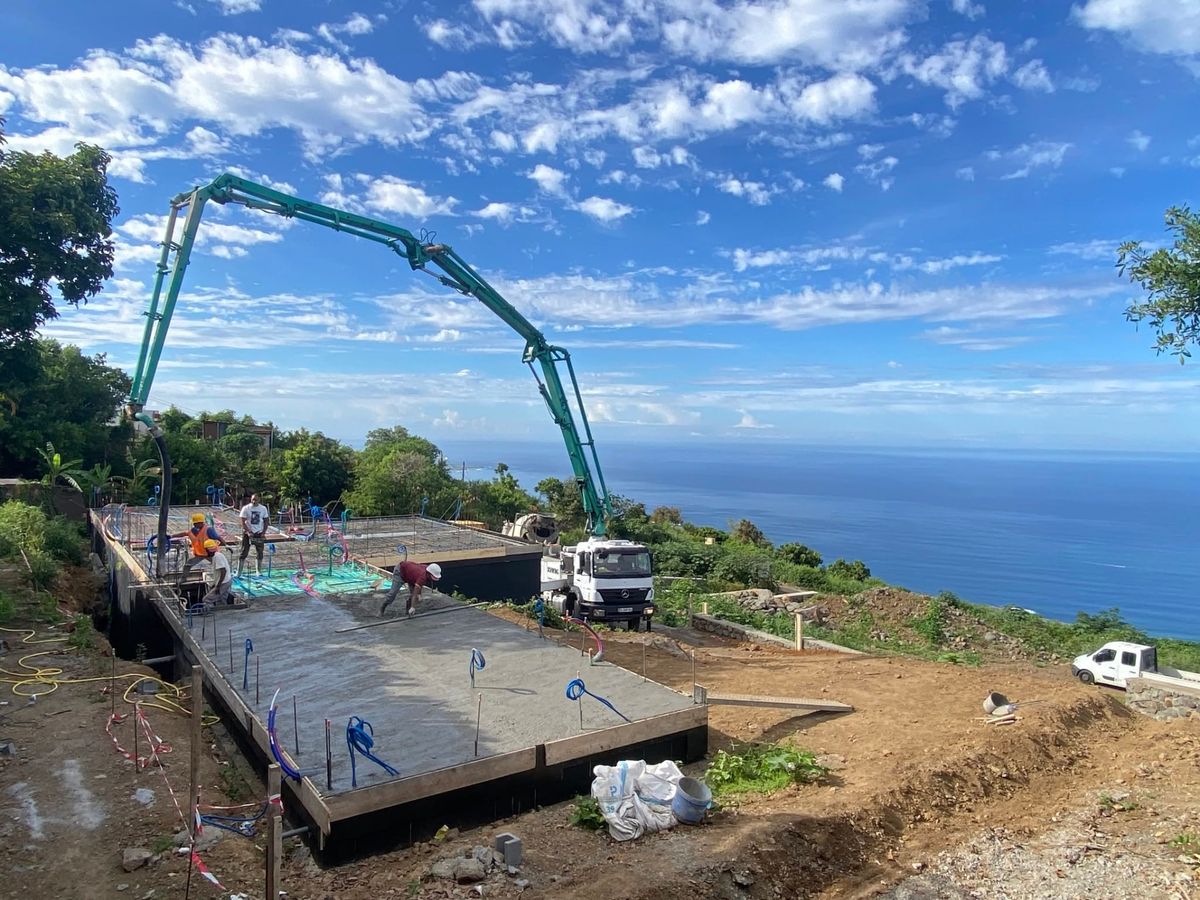 Chantier de préparation : dalle coulée à la pompe à béton face à l'océan